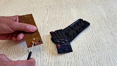 Hands Repairing Remote Control Circuit Board with Screwdriver Stock Footage 340746825