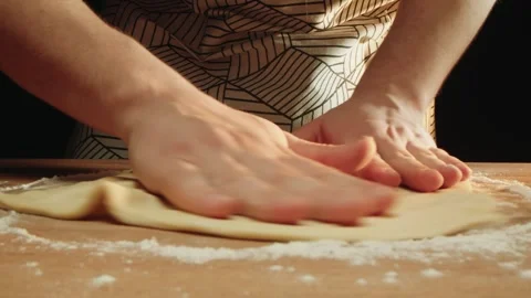 Hands rhythmically press dough into circle on floured kitchen table 스톡 동영상 331846734
