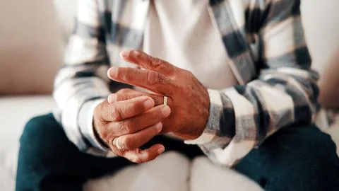 Hands, ring and thinking with old man on sofa in home living for grief, los.. Stock Photos