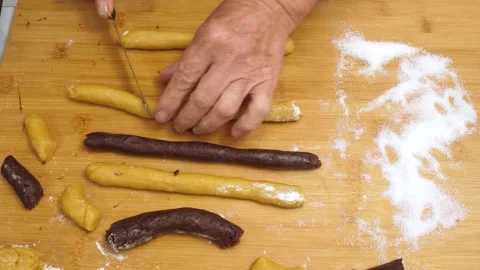 Hands roll the dough and cut it into pieces, top view Stock Footage 320068006
