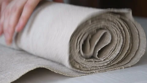 Hands roll homemade linen into a scroll Stock Footage 137643234