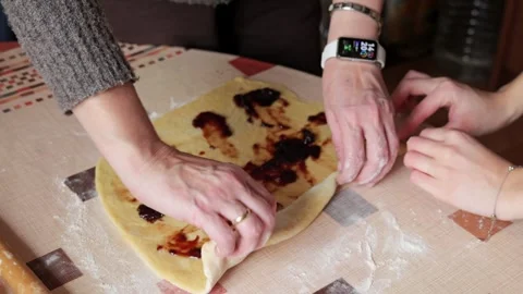 Hands rolling brioche dough with jam filling close up Video stock 332679651