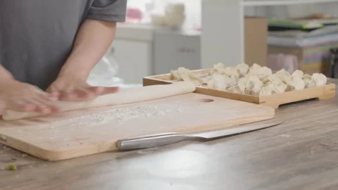 Hands Rolling Dough into Long Strips on Wooden Board for Dumplings 動画素材 336530105