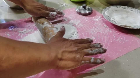 Hands Rolling Dough on a Pink Mat in a Kitchen Preparation Process Stock Footage 311513930
