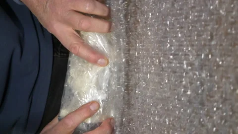 Hands rolling an ornament in bubble wrap packaging. Video stock 221252749