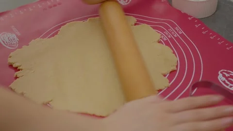 Hands rolling out cookie dough in a cozy kitchen Stock Footage 329281713