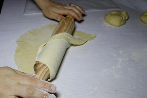Hands on the rolling pin that stretch the dough Stock Photos