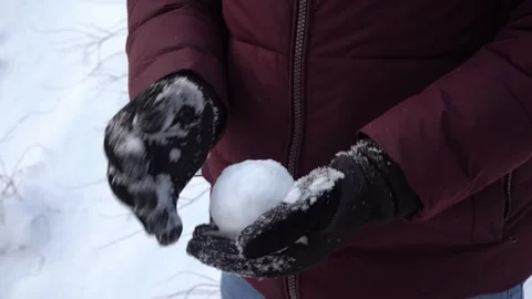 Hands rolling snowball in winter gloves outdoors, close-up winter activity Stock Footage 326824019