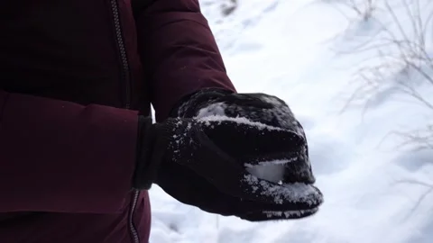 Hands rolling snowball in winter gloves outdoors, close-up winter activity Stock Footage 326824021