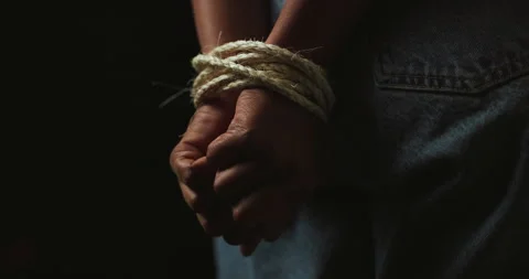 Hands, rope and prisoner for hostage, victim and kidnapping on black background Stock Footage 309824581