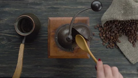 Hands rotating the handle of retro bronze coffee grinder mill Stock Footage 290517040