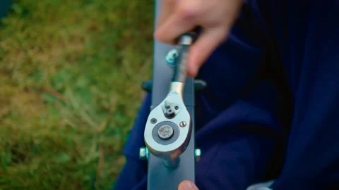Hands rotating socket wrench securing fastener on steel frame element in Video stock 342501830