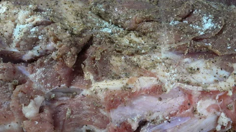 Hands rub salt into a raw piece of meat in 4K closeup Stock Footage 129549607