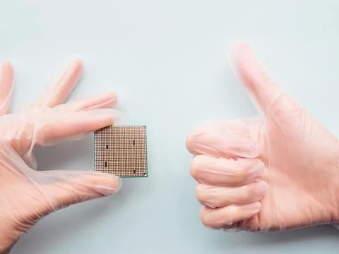 Hands in rubber glove with Central Computer Processor. CPU on light blue back Stock Photos