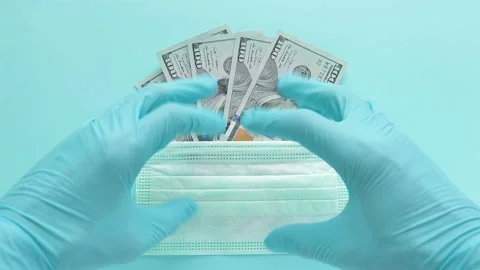 Hands in rubber gloves over protective mask dollar banknotes on blue background Stock Footage 126698202