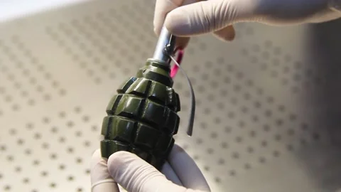 Hands in rubber gloves spin a hand grenade Video stock 222186818