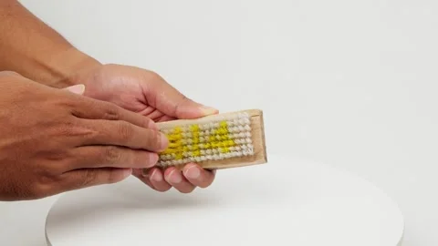 Hands Rubbing a Brush Back and Forth Stock Footage 327848752