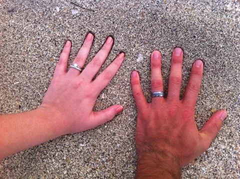 Hands in the Sand with wedding rings Stock Photos