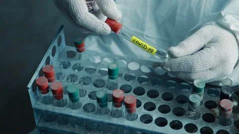 Hands of a scientist doing a virus test and holding a COVID-19 test tube Stock Footage 131460545