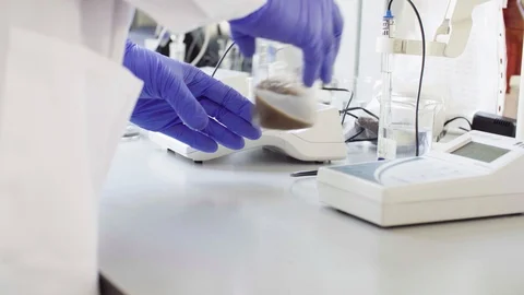 Hands of a scientist measuring pH of the sample Stock Footage 90385466