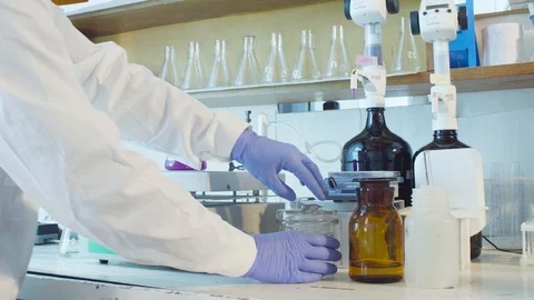 Hands of a scientist putting the funnel in a flask Video stock 91612144