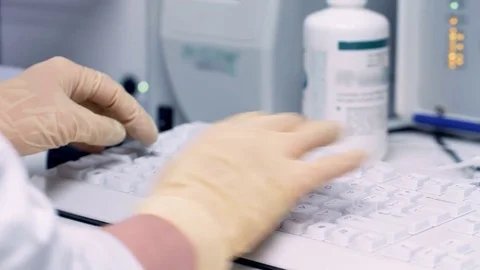 Hands scientist scoring data to a computer in laboratory Stock Footage 71684141