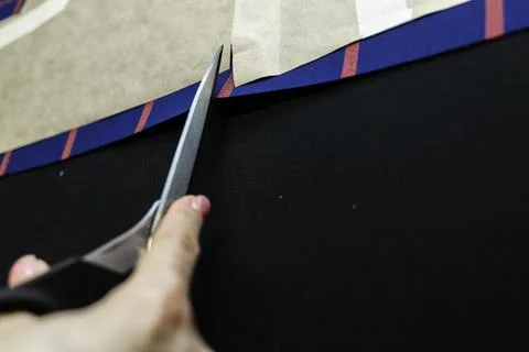 Hands with scissors on the fabric Stock Photos