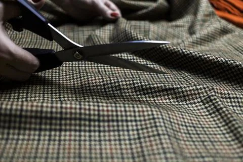 Hands with scissors on the fabric Stock Photos