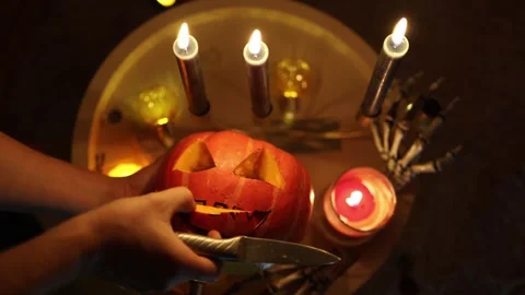Hands scoop pumpkin pulp while making jack o lantern for Halloween party Stock Footage 346147312