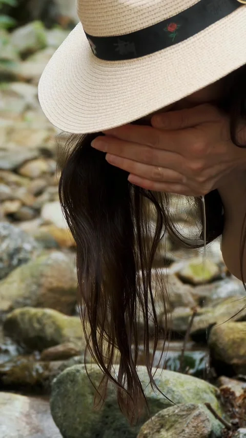 Hands scooping water from a river in the Alpine mountains. The girl drinks clean Stock Footage 310108137