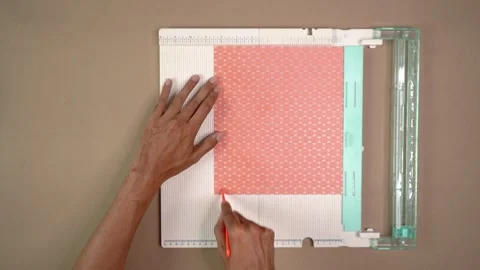 Hands Scoring Patterned Cardstock With Tool on Craft Board for DIY Paper Stock Footage 345271331