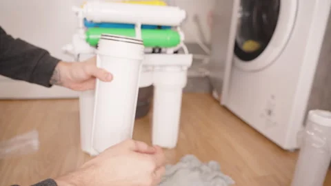 Hands Screwing on a New Filter Housing Bulb into the Reverse Osmosis System, Stock Footage 296573723