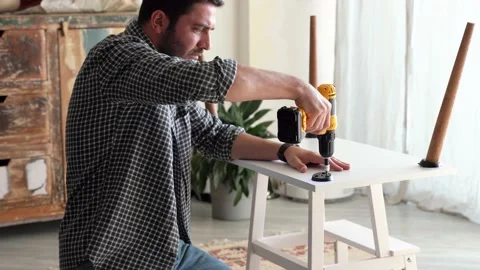 Hands screws the legs of the table Stock Footage 167265715