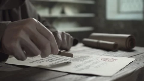 Hands of a scribe with a wooden spatula scattering sand on an illuminated page 스톡 동영상 339631310
