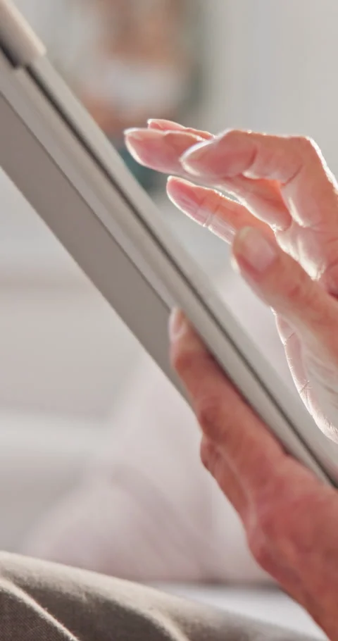 Hands, scrolling and tablet with old woman in home living room for break, search Stock Footage 338425084