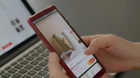 Hands Scrolling Shopping App on Red Smartphone Displaying Product Details Vídeos de archivo 336529210