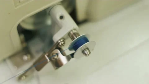 Hands of a seamstress winding thread from a spool to a bobbin, close-up. Video stock 152512216