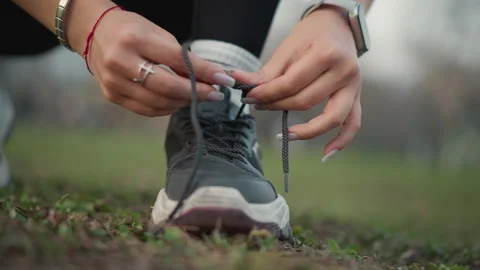 Hands Securing Athletic Shoe Laces, Person Tying Sneakers In Park, Detailed Stock Footage 333641723
