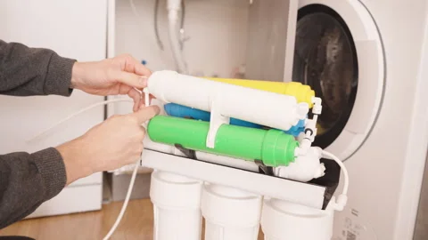 Hands Securing a White Reverse Osmosis Filter Cartridge into the System with Stock Footage 296571751