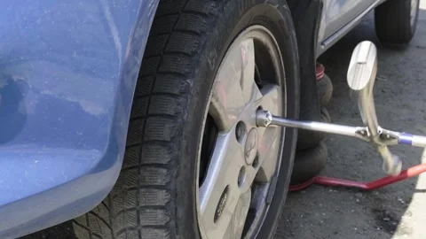 Hands of a senior auto mechanic changing tires Stock Footage 273449778