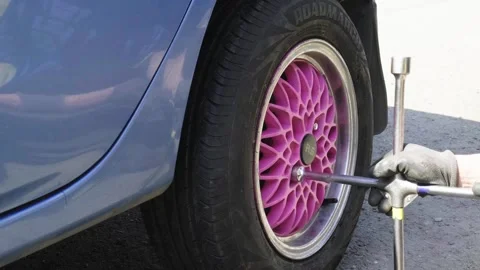 Hands of a senior auto mechanic changing tires Stock Footage 273451579