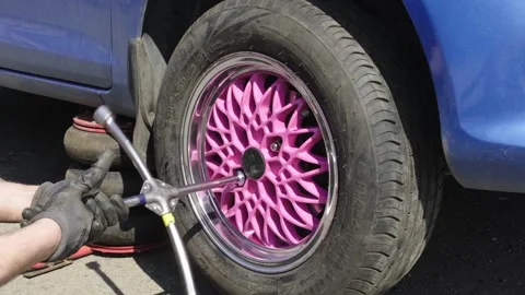 Hands of a senior auto mechanic changing tires Stock Footage 273452208