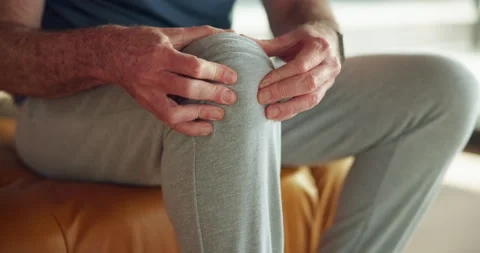 Hands, senior man and knee pain in home with arthritis, muscle tension and Stock Footage 318729692