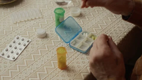 Hands of Senior Man Sorting Medication into Pill Organizer Vídeo Stock 337572520
