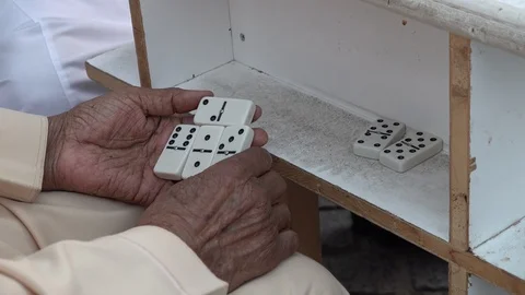 Hands of senior Saudi man playing domino outdoor in historic Al Balad Jeddah Stock-Footage 125717751