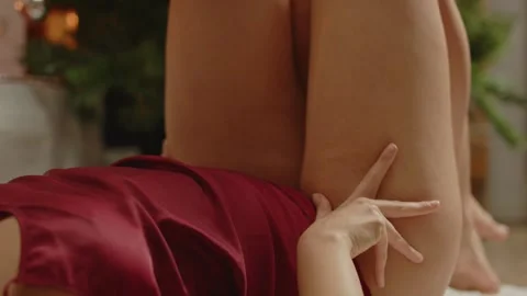 Hands sensually caressing the legs of an attractive woman lying in front of a Video stock 297196154