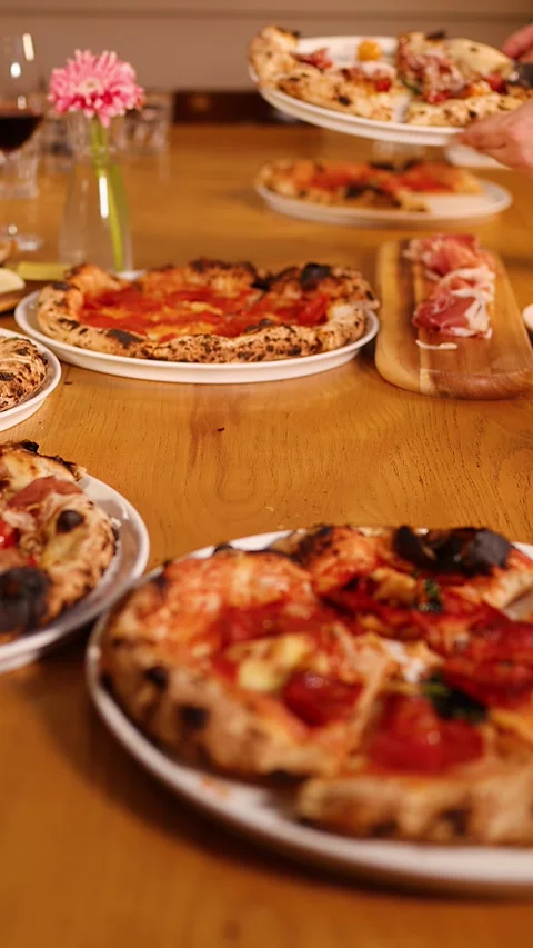 Hands Serving Fresh Neapolitan Pizzas on a Restaurant Dining Table 스톡 동영상 338055069