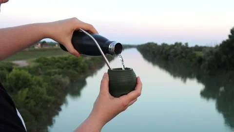 Hands serving yerba mate (chimarrão) into a silicone mate gourd Stock Footage 303224351