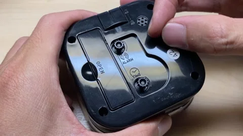 Hands setting up alarm clock dial and rewind clock dial close up. Setting up Stock Footage 249234676