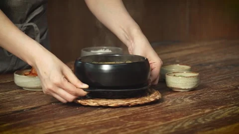 Hands Setting Down Hot Soup Pot on Table Close Up Stock Footage 335614168
